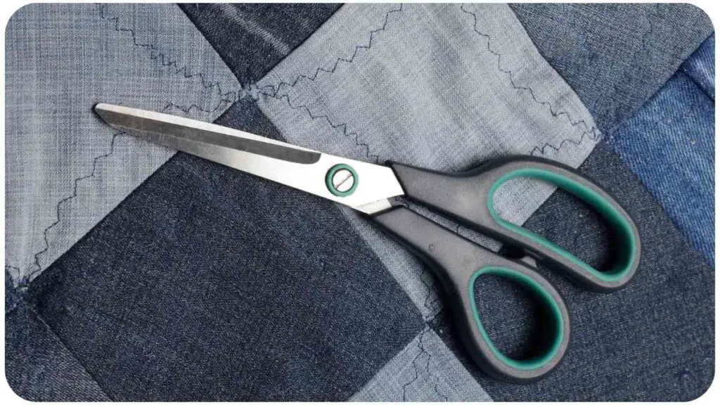 a pair of scissors sitting on top of a patchwork quilt