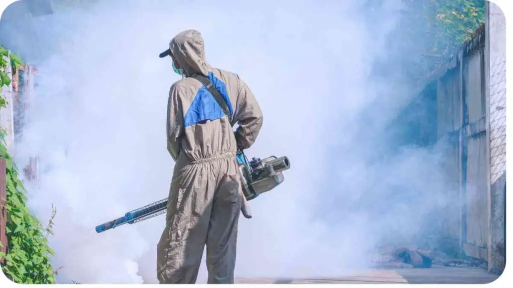 a person wearing a protective suit and holding a sprayer