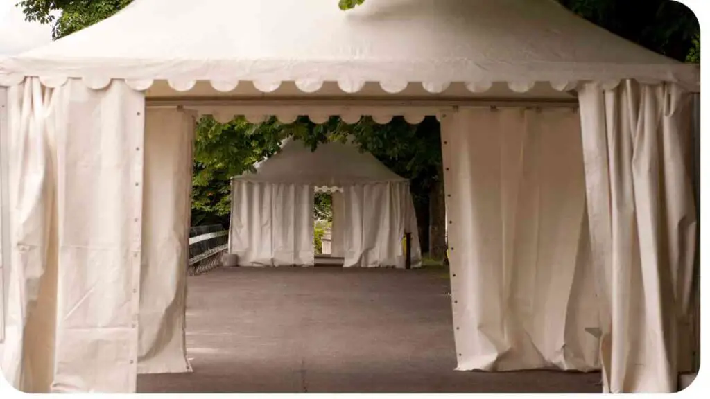 a tent with white curtains on the side of the walkway