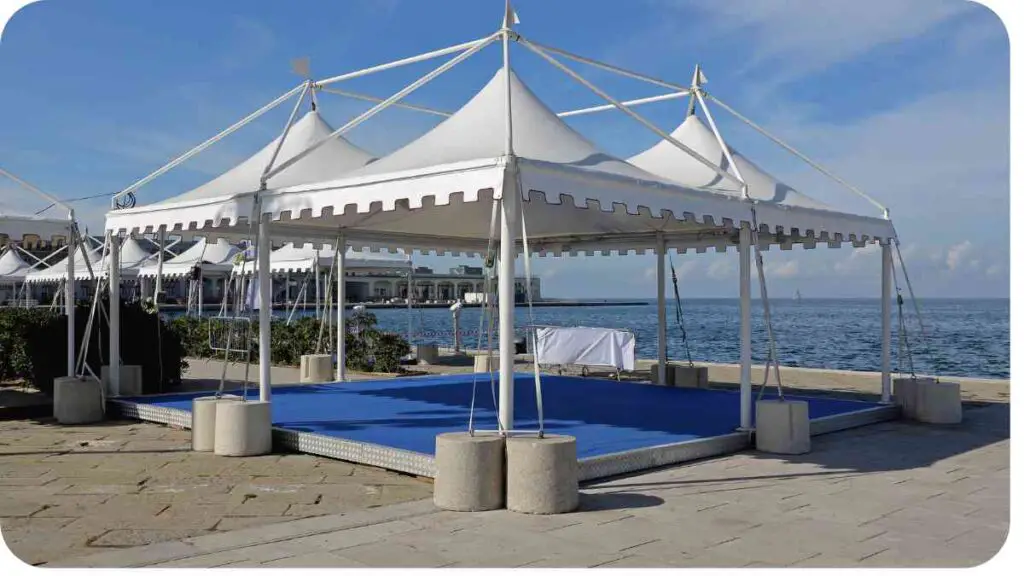 a large white tent with blue carpet on the ground