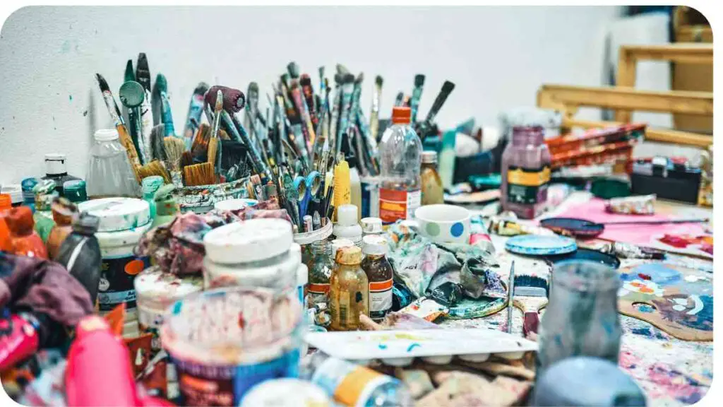 many different types of paint and brushes on a table