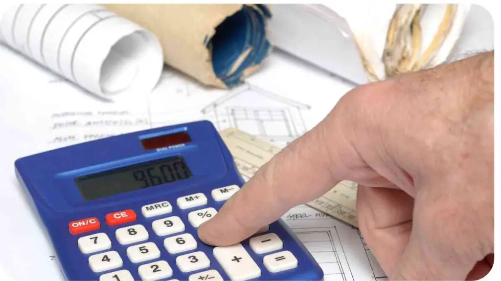 a hand pointing to a calculator on top of construction plans