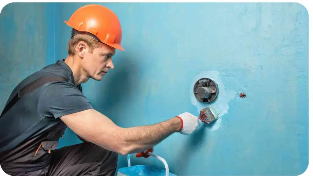 a person is painting a wall with blue paint