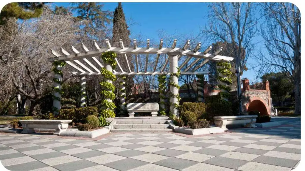 an outdoor gazebo in a park with trees and shrubs