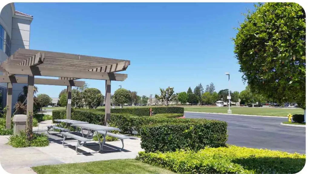 a park with picnic tables and a gazebo in front of a building