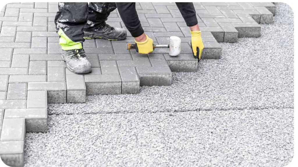 a person is laying bricks on a sidewalk